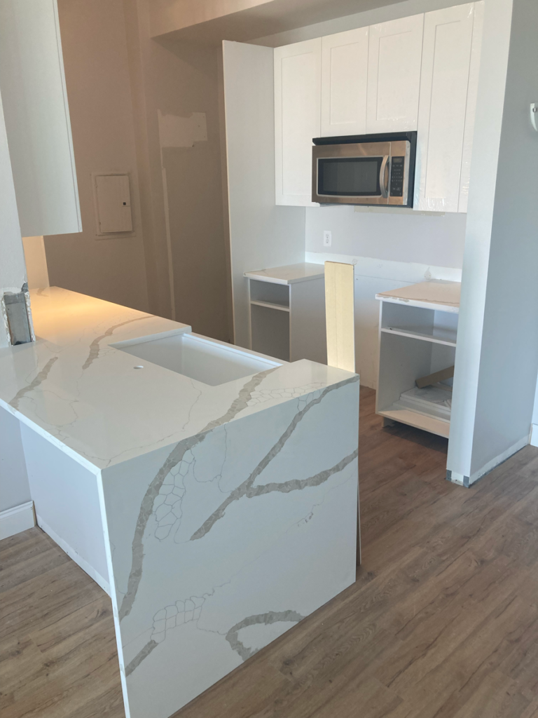 White Kitchen Cabinets in Remodeled Kitchen with a Stainless Stell Microwave | Gallery Showcase