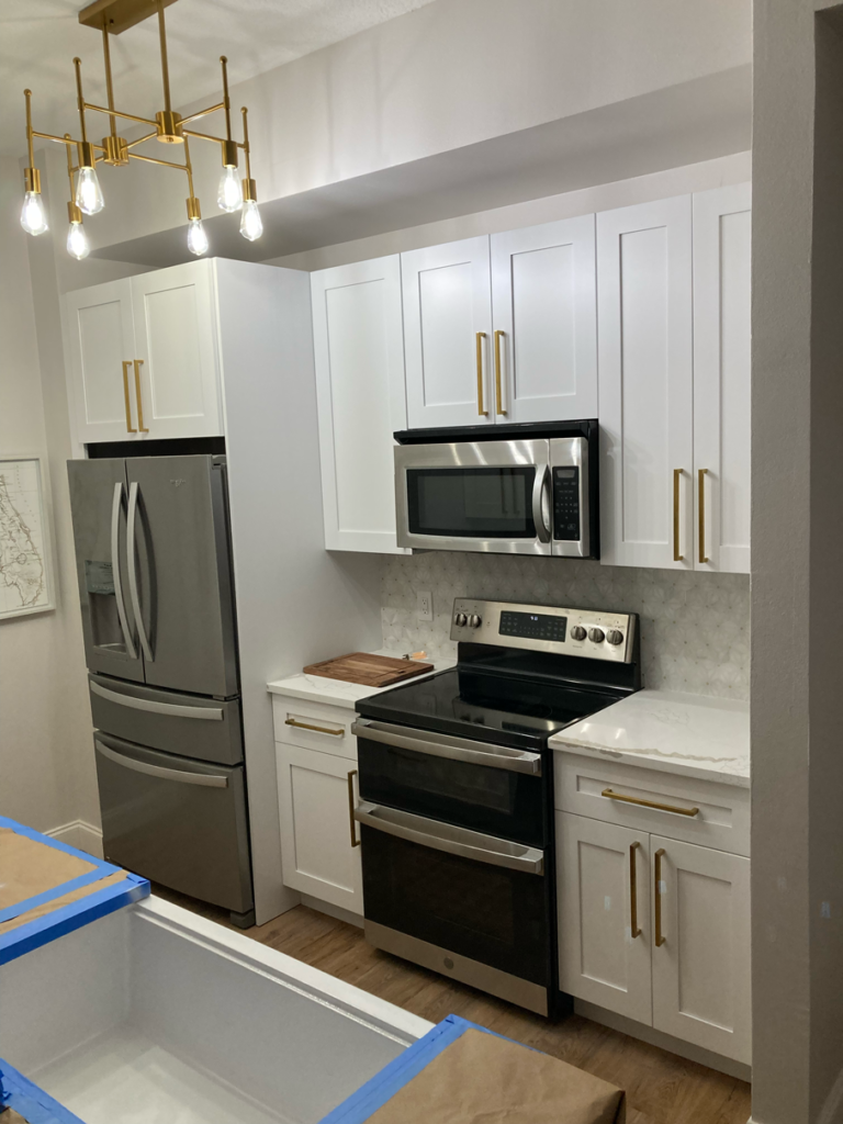 White Kitchen Cabinets in Remodeled Kitchen with a gold hardware | Gallery Showcase